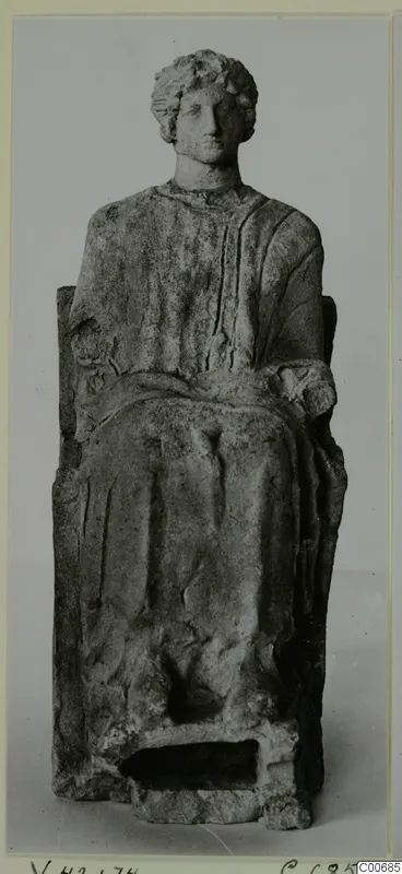 Seated figurine with curled hair and a draped garment, on a high-backed seat, from Vouni.
