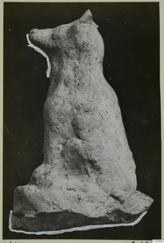 Terracotta figurine of a seated animal with upright pointed ears and a long muzzle