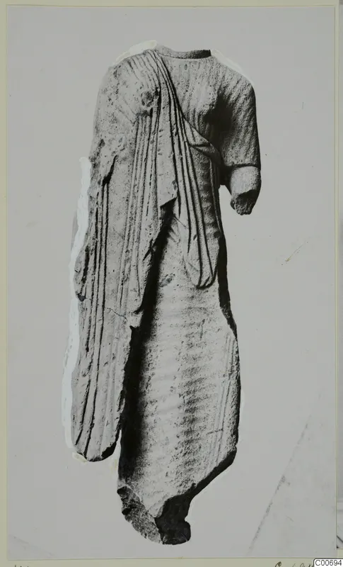 Limestone statue fragment of a draped standing figure from Vouni, head and legs missing, one arm broken short