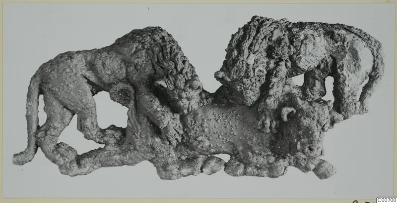 Corroded bronze relief of two lions attacking a bull, photographed flat against a pale background.