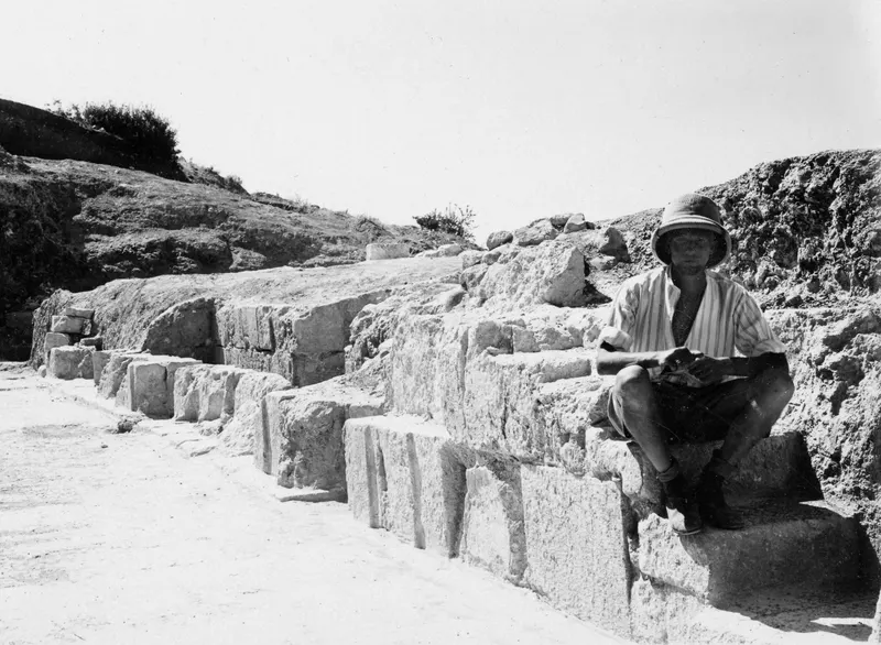 Alfred Westholm seated on the dressed stone facade of the stage at the theatre at Soli