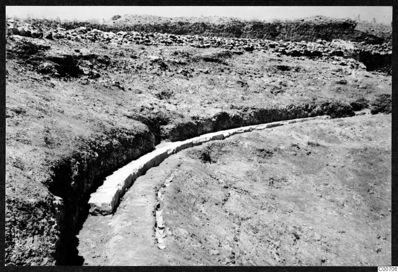 Curved row of pale cut stone blocks exposed in an excavation at Soli, the theatre