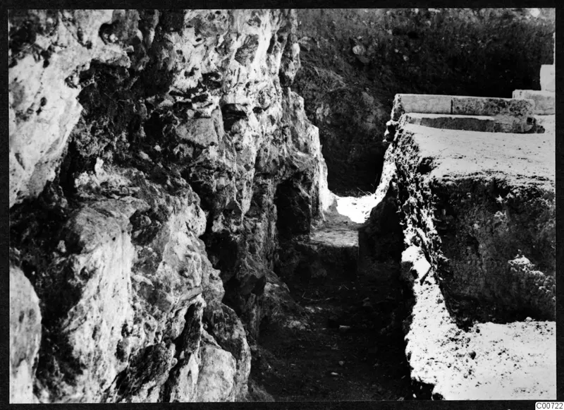Excavated cutting at Soli theatre, with a rough rock face on one side and dressed stone blocks along the top of the bank