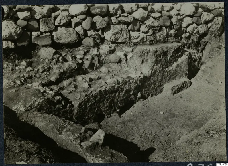 Excavation at Soli showing a stone construction with a rubble stone wall behind it.