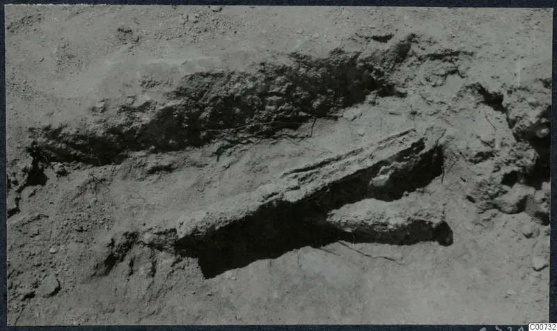 Excavated trench at Vouni with a long stone block partly uncovered in the soil.