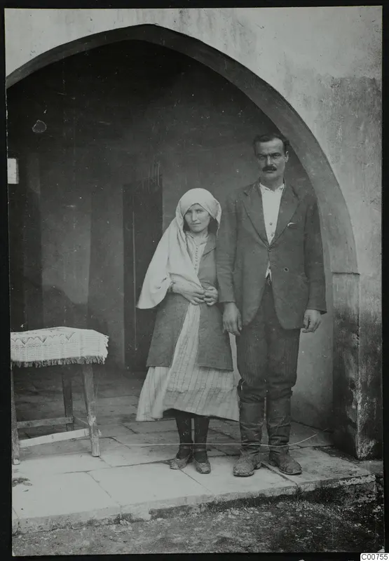 The mukhtar with his wife standing in an arched doorway at Ayios Iakovos