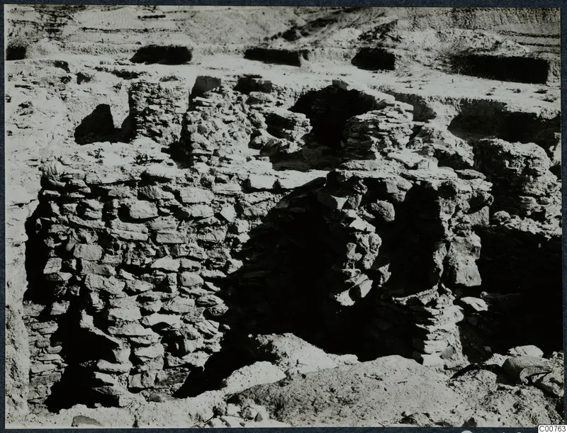 Excavated stone walls and dark openings at Idalion acropolis during excavation