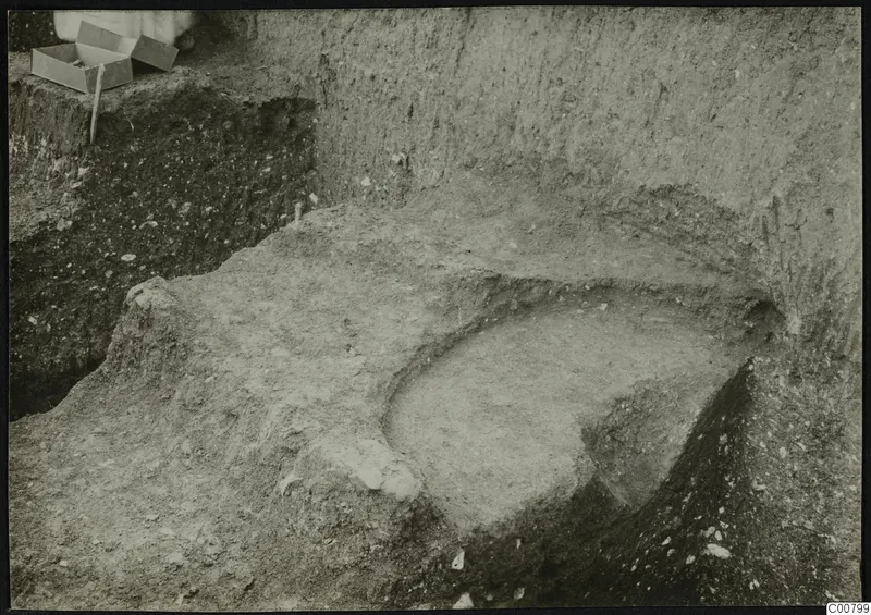 Excavation at Plakes, Lapithos, with a small cardboard box and a stake at the upper left of a cut in the soil.
