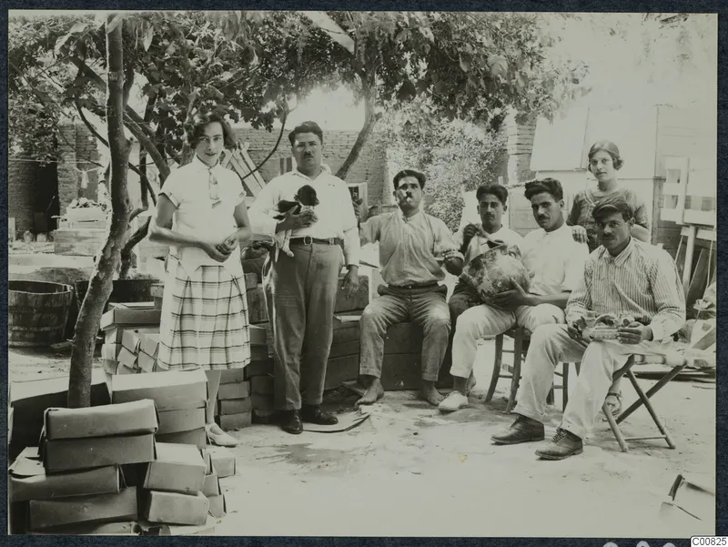 Rosa Lindros and Ttoulis Souidos with workmen in a garden in Nicosia, seated and standing under a tree