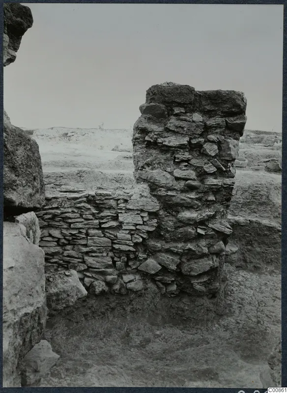 Standing stone wall remains on the Idalion acropolis, with a wall running left beside a tall rubble-built pier.