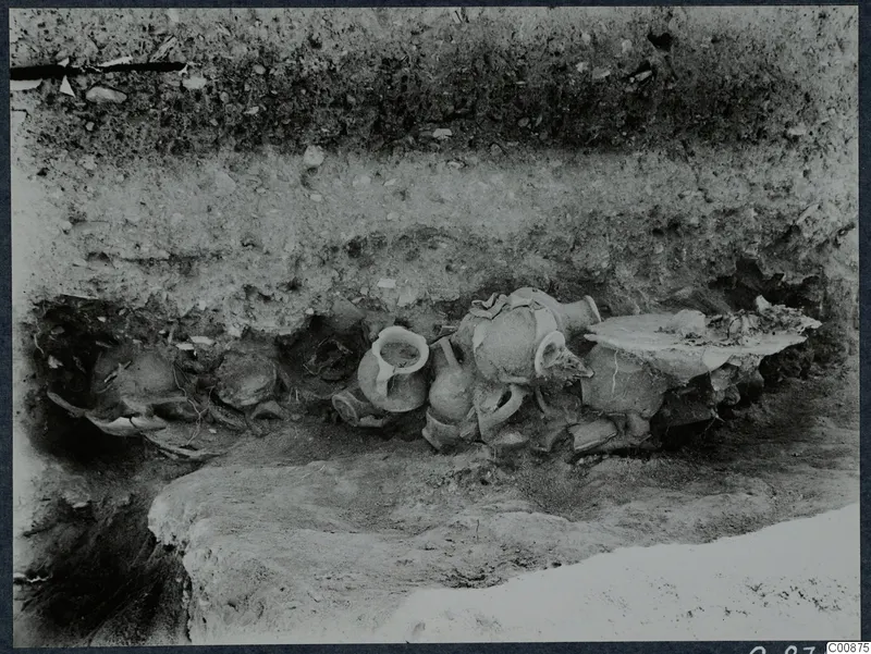 Pottery vessels lying in situ in excavated trench G 6-7 at Idalion, set against a layered soil section