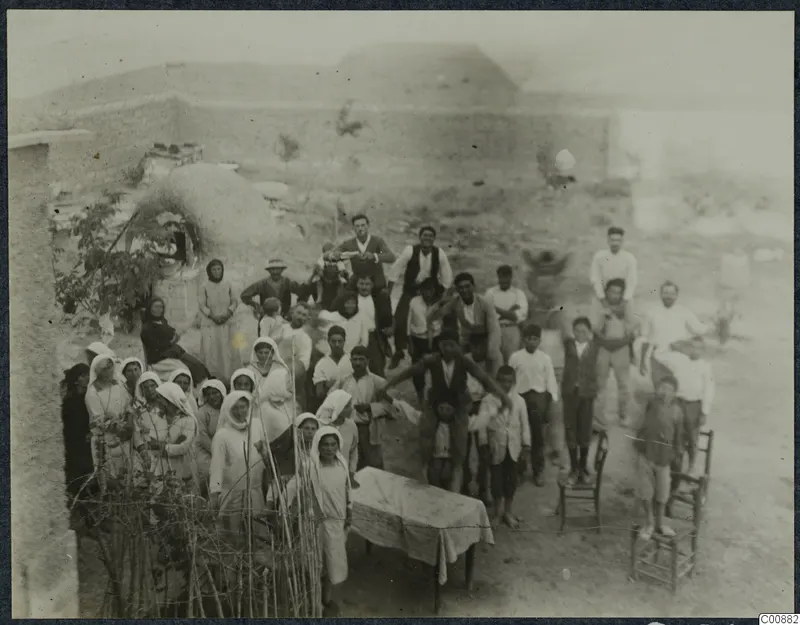 Farewell party of a crowd of people gathered in a dusty yard at Panajiotis, Idalion.