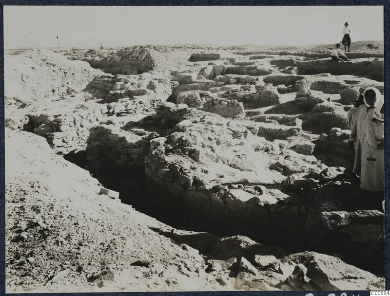 Excavation at Idalion Acropolis with exposed stone walls and people standing among the rubble