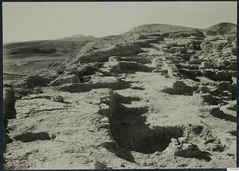 Excavated wall foundations on the Idalion acropolis, with a trench in the foreground and hills behind.