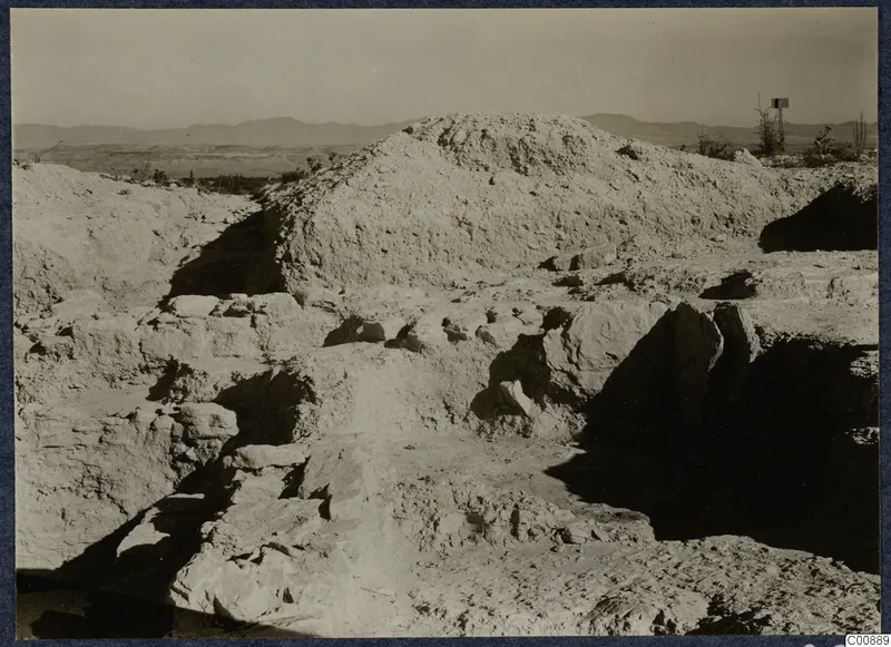 Excavated mound and cut stone walls on the Idalion acropolis, with hills in the distance