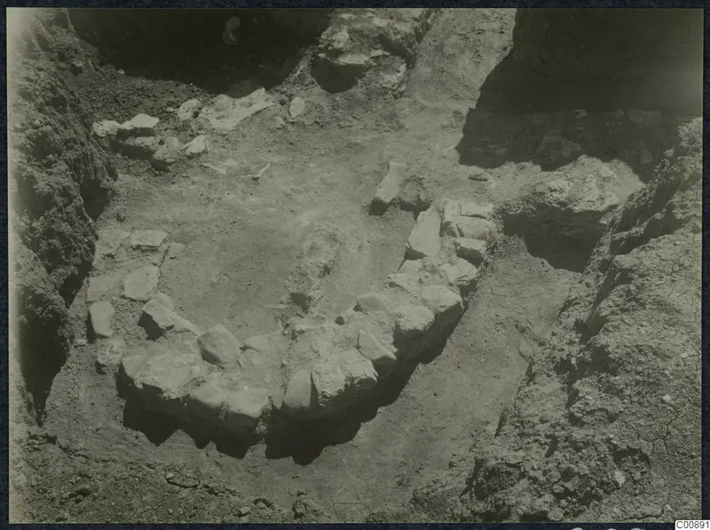 Excavation trench at Idalion with a curved line of stones set into the soil.