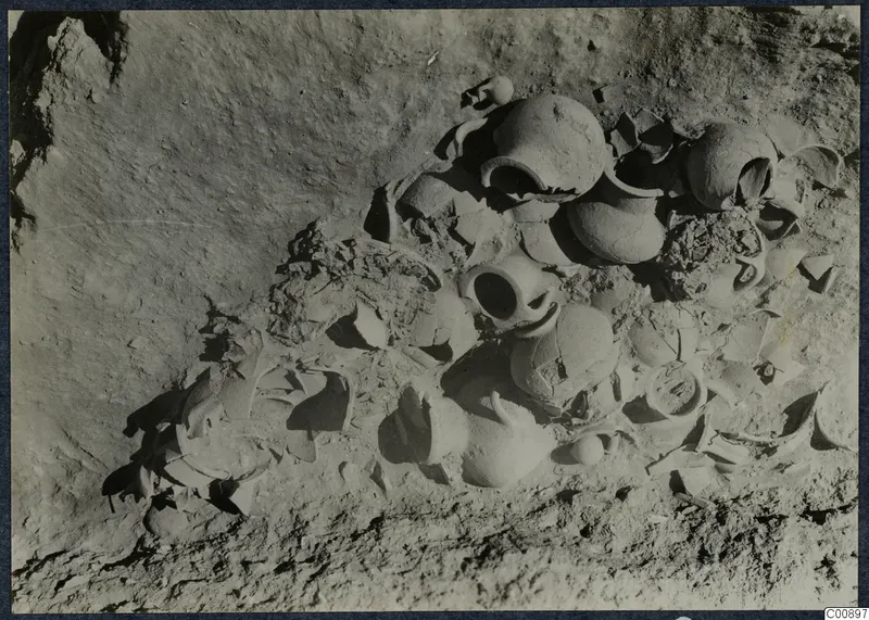 Pottery vessels and broken sherds lying in excavated soil at Idalion Acropolis