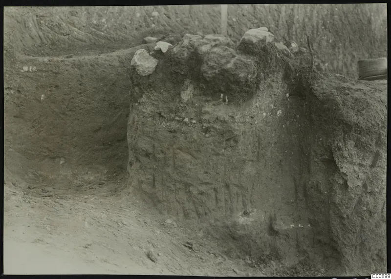 Excavated soil face at Plakes, Lapithos, with large stones lying on top of the earth bank