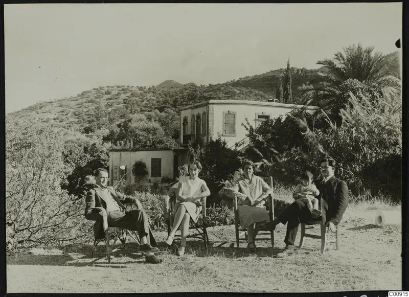Erik Sjoqvist, Rosa Lindros and others seated outdoors in front of a white house on a hillside.