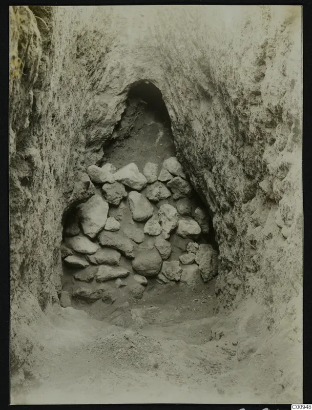 Tomb 417 at Lapithos during excavation, showing a burial chamber opening filled with stacked stones.