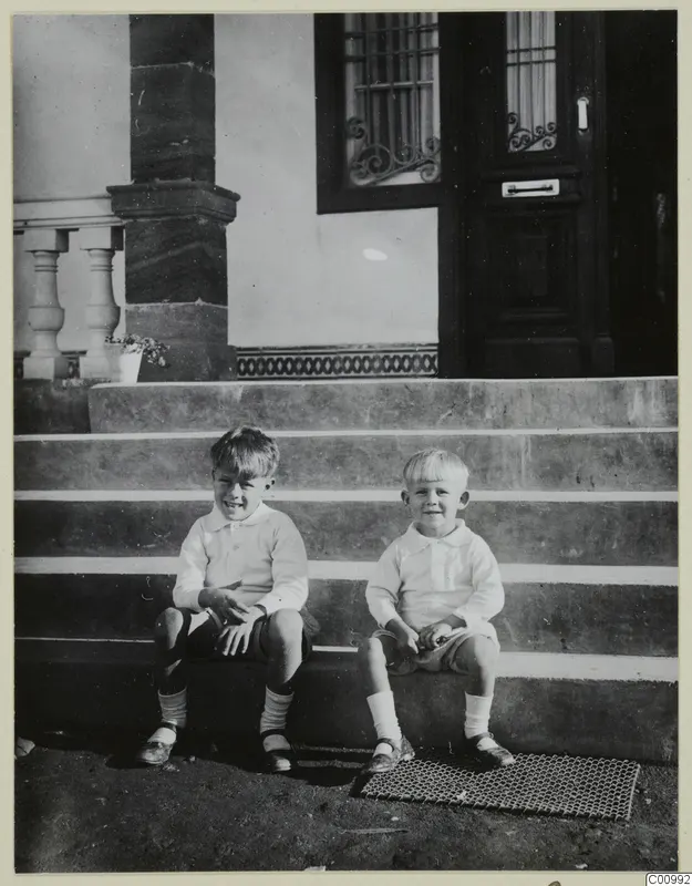 Martin and Stefan Gjerstad sitting on stone steps in front of a house door, Nicosia.