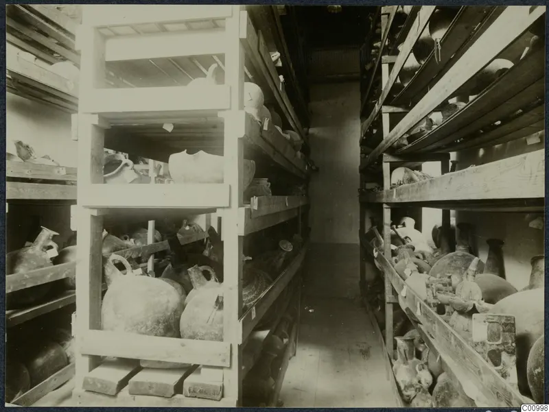 Storeroom with pottery vessels on wooden shelves and planks, Nicosia