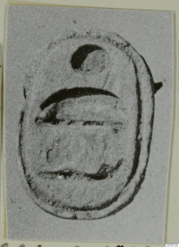 Scarab-shaped seal with a dark crescent mark near the top and horizontal lines across its base