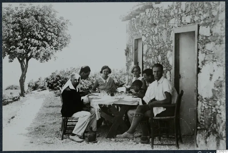 People at a breakfast table outside a stone building at Vouni