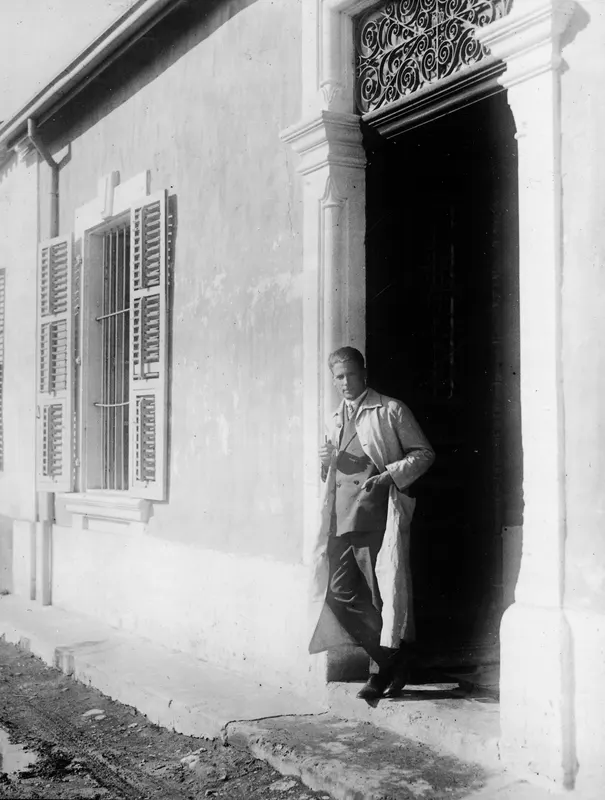 Alfred Westholm standing in a doorway of a whitewashed building with shuttered windows, Nicosia