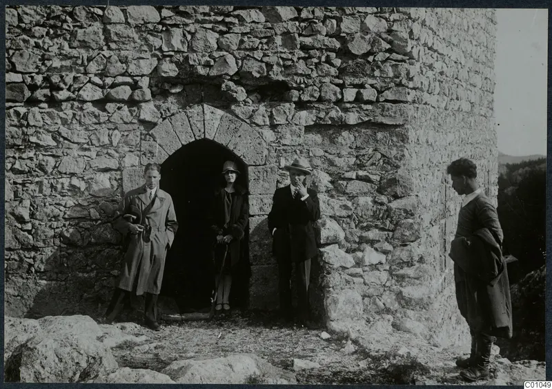 Four people standing by an arched doorway in a rough stone tower at St. Hilarion
