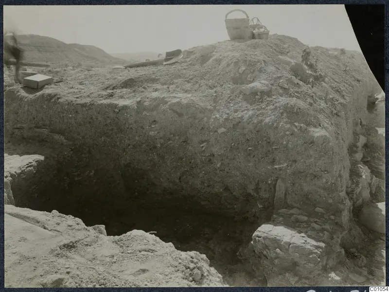 Excavation at Idalion Acropolis with baskets and stones on the spoil heap above a trench