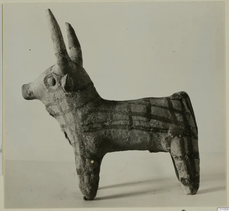 Terracotta figurine of a horned cattle with dark painted bands in a grid pattern