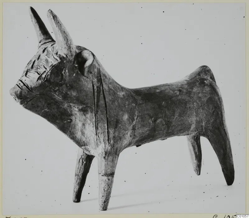 Terracotta figurine of a bull with long upturned horns and incised markings on the head and body.
