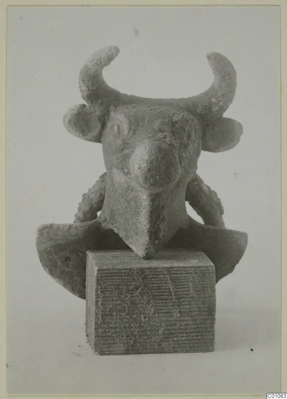Small horned bull-head figure mounted on a block, front view