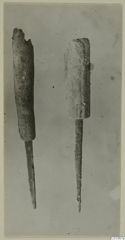 Two corroded metal awls with thick cylindrical upper parts and long pointed shanks, from the Vrysi tou Barba tombs at Lapithos