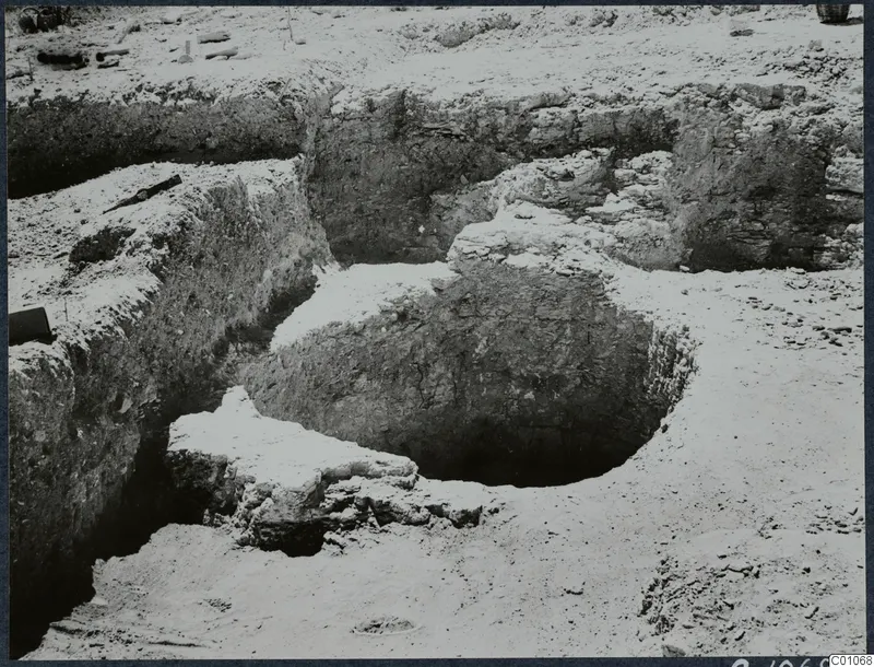 Excavated well at Idalion: a circular pit cut into layered soil, with a rough stone lip on one side