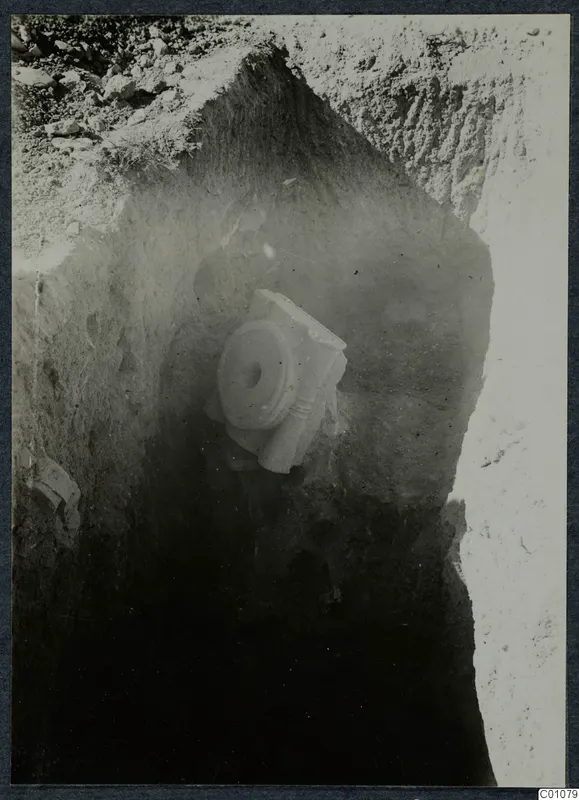 Excavation at Idalion with a pale stone architectural fragment lying in the excavated soil face