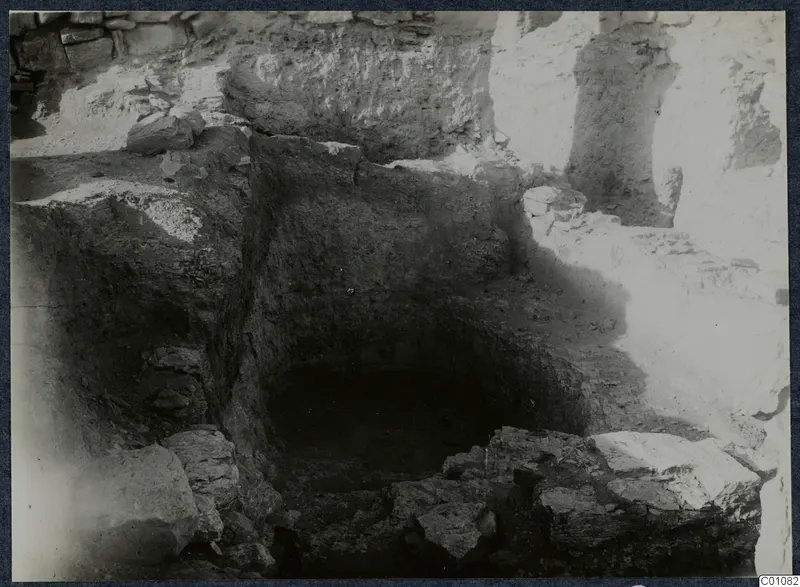 Excavated pit with stone blocks at the edge, among walls, at Idalion acropolis