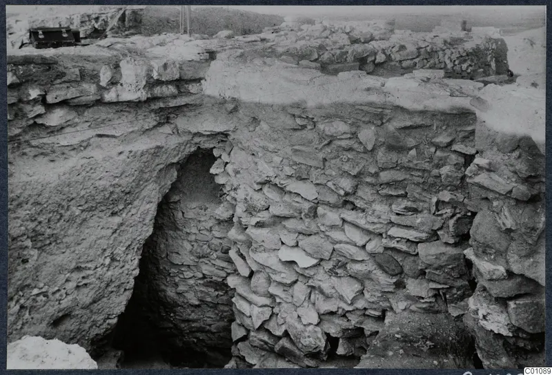 Excavated stone walls and a dark arched opening at Idalion Acropolis