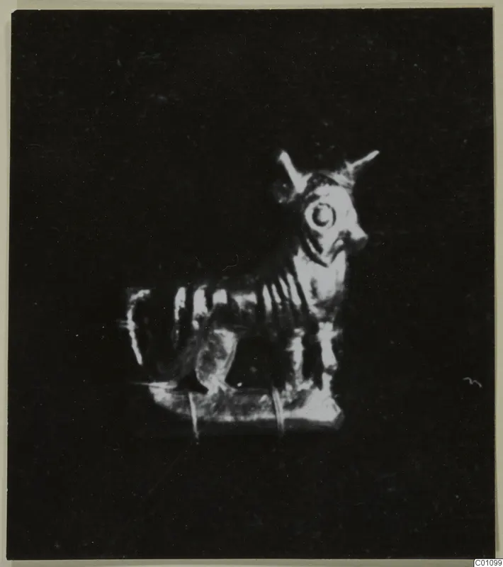 Small figurine of a horned animal standing on a flat rectangular base