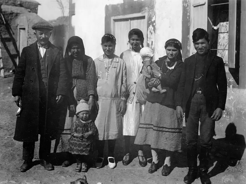 Group photograph of the Neofytou family standing in a row outside a whitewashed house in Milia