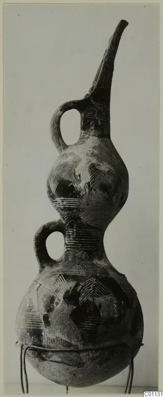 Red Polished III amphora, a double-gourd vessel with a tall spout and two loop handles, incised with chevrons and bands