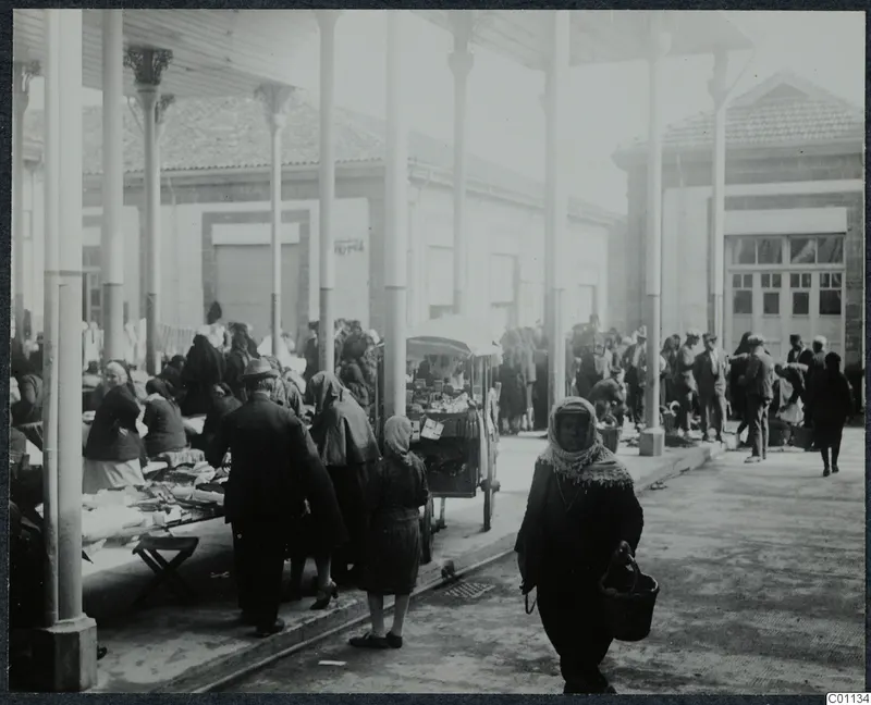 Market square in Nicosia: a crowd of people walking and trading under a colonnade of tall white pillars