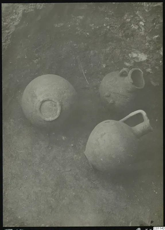 Three clay vessels lying in the soil during excavation of Tomb 13 at Marion