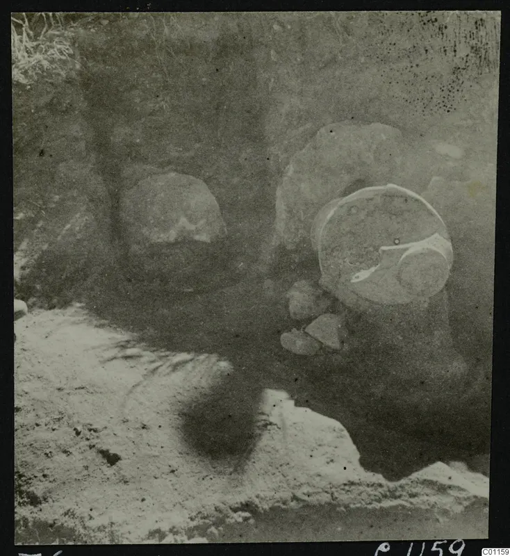 Tomb 6 at Marion during excavation, with a large round vessel and loose stones in the cut