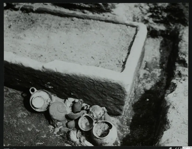 Tomb 15 at Marion during excavation, with pottery vessels lying beside a stone-edged structure