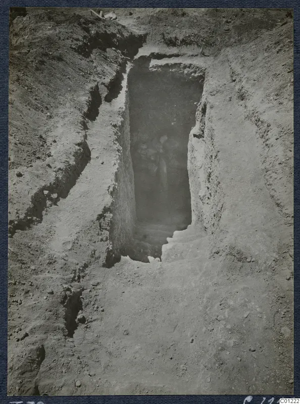 Tomb 39 at Marion during excavation: a rectangular shaft cut into soil leads down to a dark tomb entrance.