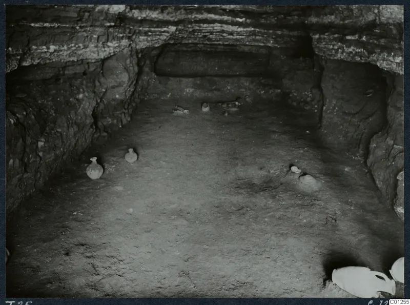 Interior of rock-cut Tomb 25 at Marion with small vessels scattered across the floor