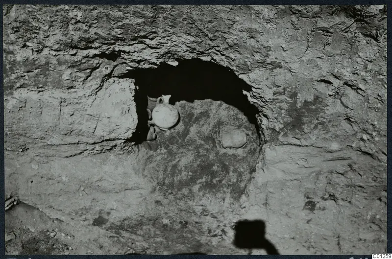 Rock-cut niche in Tomb 32 at Marion, opened, with a small handled vessel lying inside it