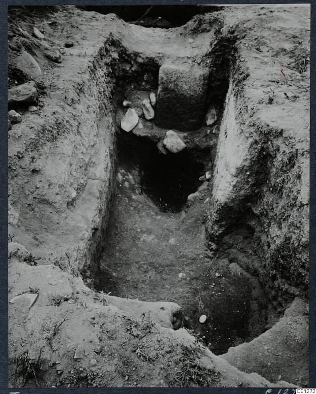 Excavation of Tomb 47 at Marion, showing a sloping cut with stones and a dark opening at its far end